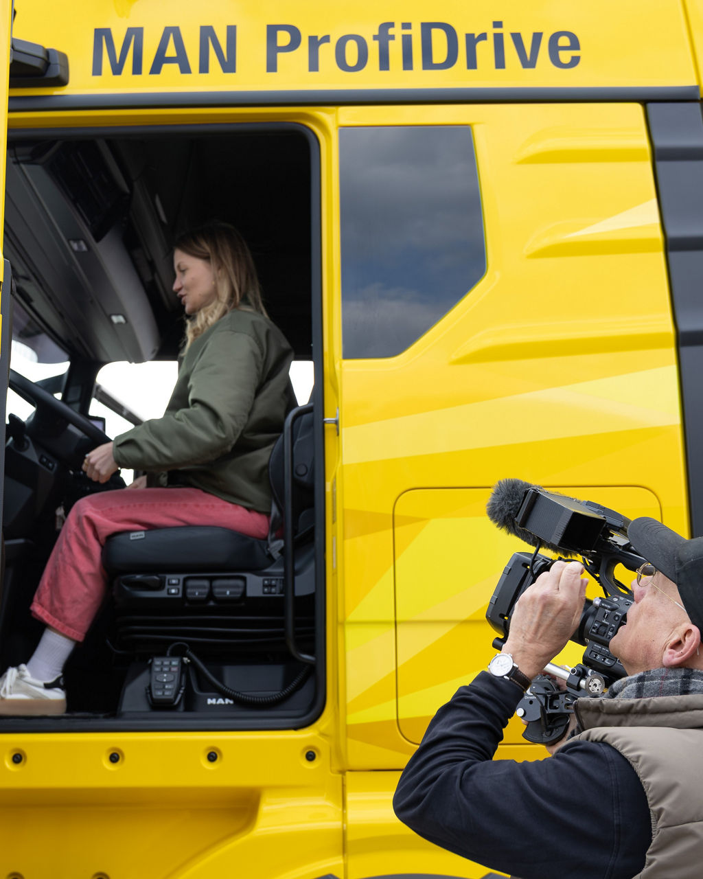 Jana Forkel sitzt im gelben MAN TGX von MAN ProfiDrive und wird gefilmt.